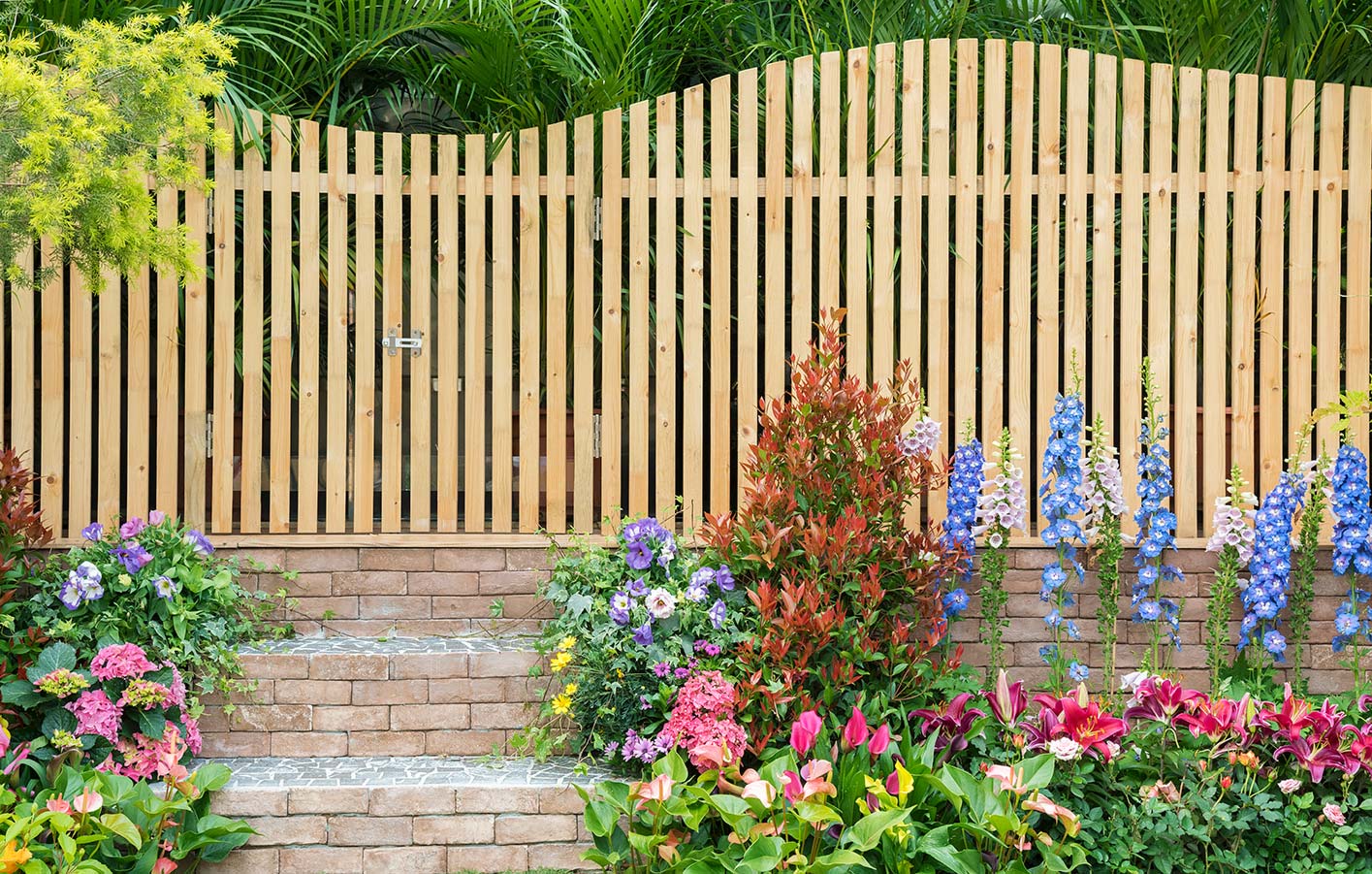 Ein schöner Holzzaun für Ihren Garten inkl. Beratung und Montage vom Fachmann schöner heller Holzzaun mit vielen Blumen