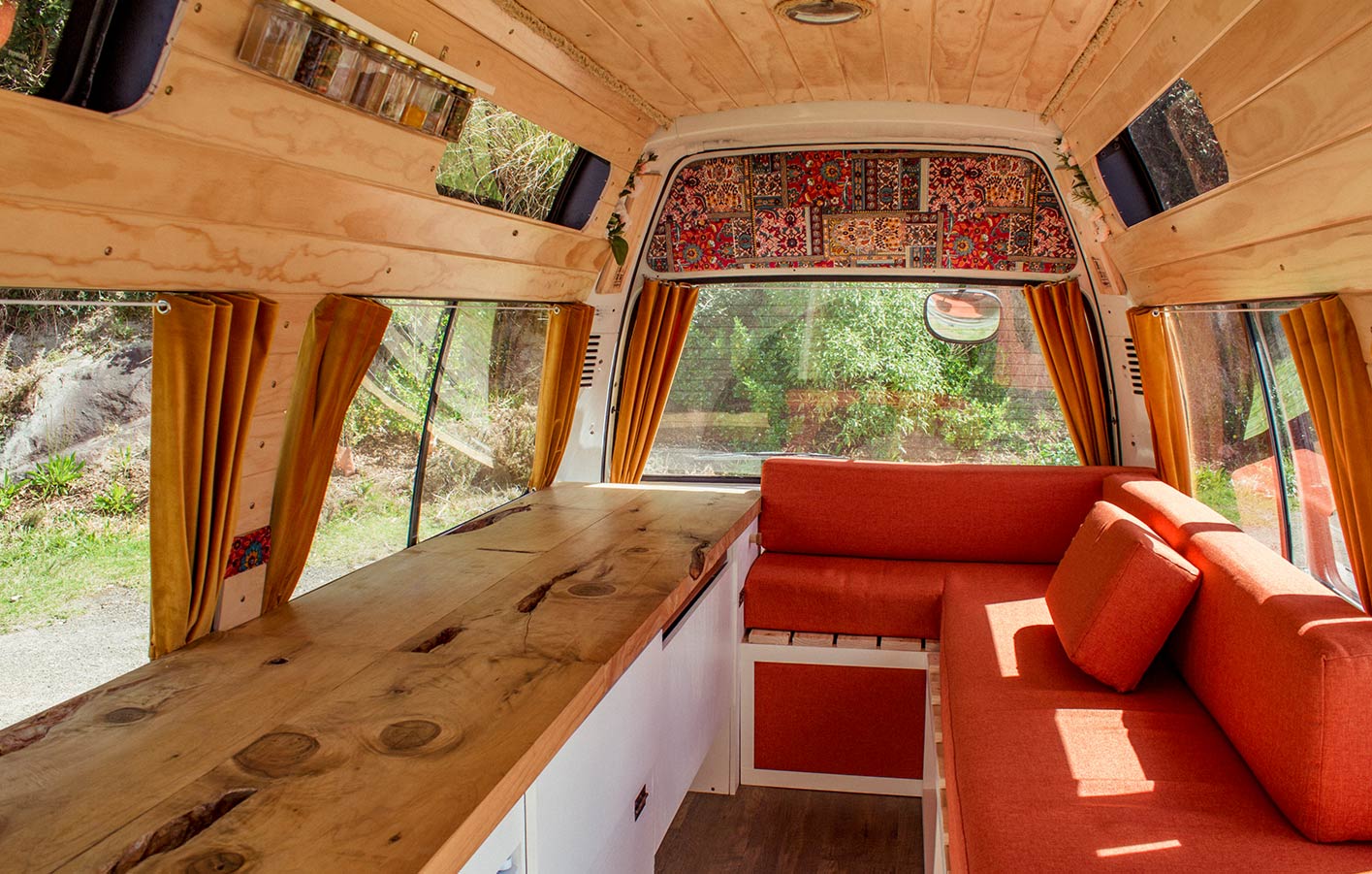 Innenausbau mit Holz: Komfortables Wohnmobil mit gemütlicher Atmosphäre Komfortabel eingerichtetes Wohnmobil mit Holzverkleidungen, warmen Farbtönen und gemütlicher Sitzgelegenheit, ideal für den DIY-Innenausbau.